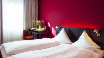 Ein Hotelzimmer mit einem Bett, einem Schreibtisch und einem Stuhl.