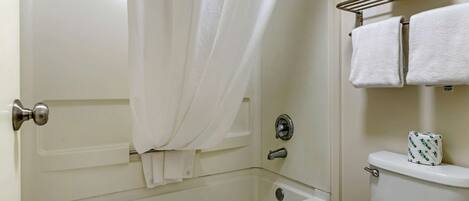 Une salle de bain avec une baignoire, des toilettes et un porte-serviettes.
