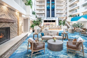 A spacious lobby with a bar area, seating arrangements, and a fireplace.