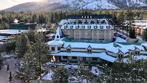 A large, multi-story hotel with a traditional architectural style, featuring a prominent central building with a green roof and multiple windows.
