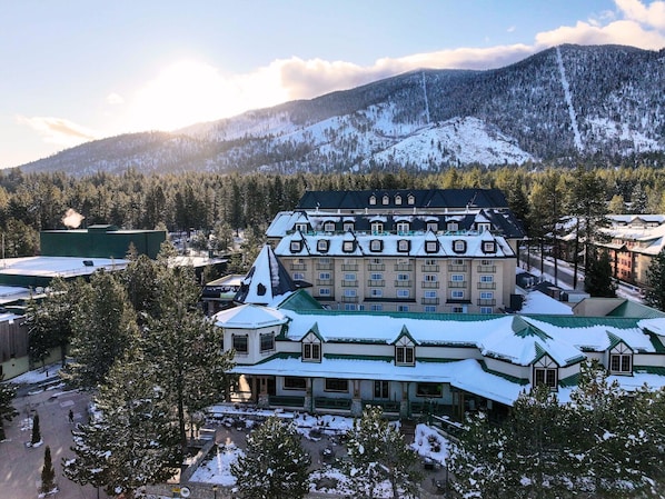 A large, multi-story hotel with a traditional architectural style, featuring a prominent central building with a green roof and multiple windows.