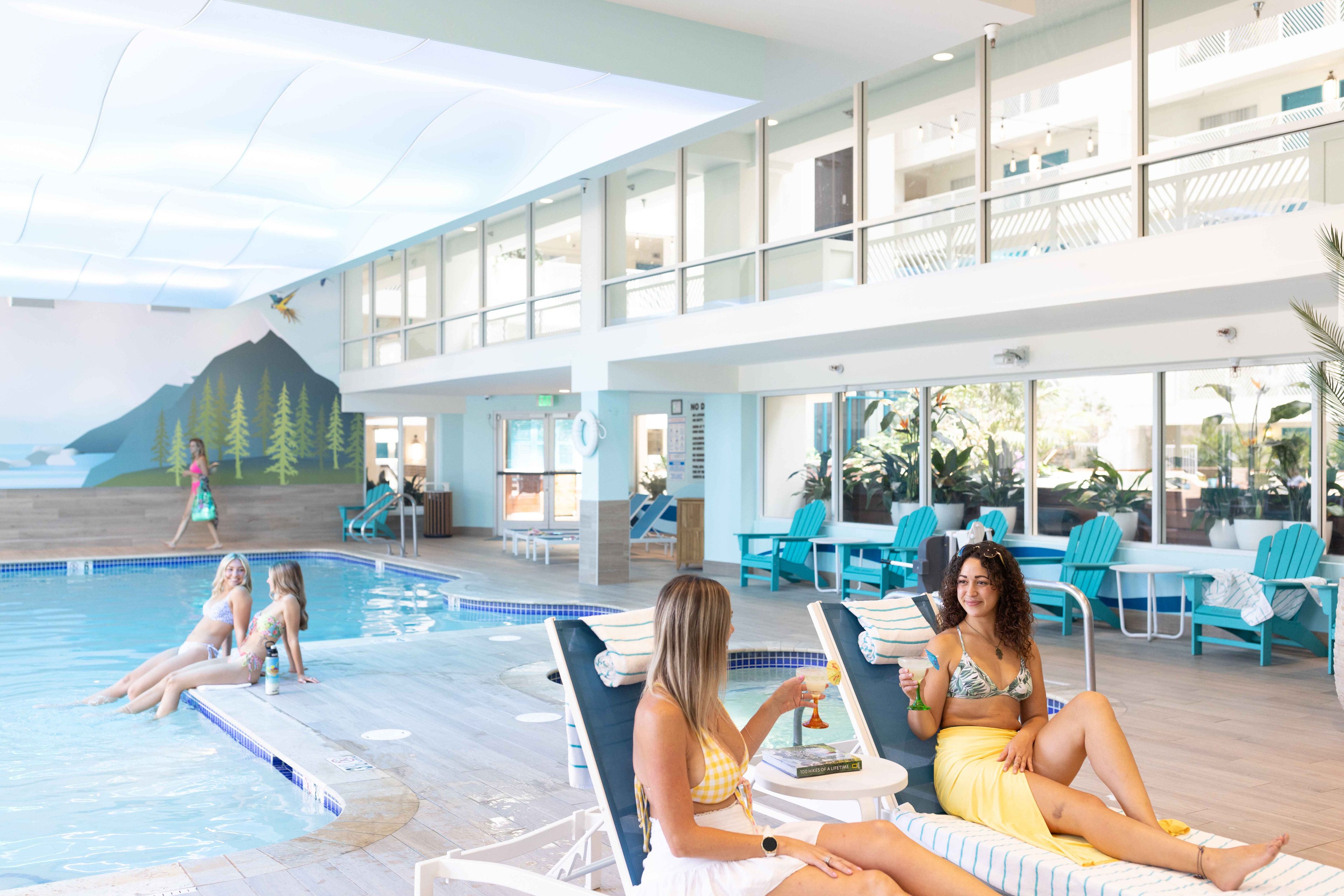 Un espace piscine avec des chaises longues et vue sur l’océan.