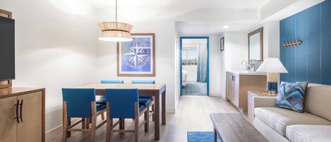 Una sala de estar moderna con comedor, un sofá, una mesa de centro y un televisor.