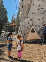 Una pared de escalada con puntos de agarre y un letrero de seguridad.