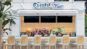 A bar with a sign reading "License to Chill Bar" and multiple bottles of alcohol on the shelves.