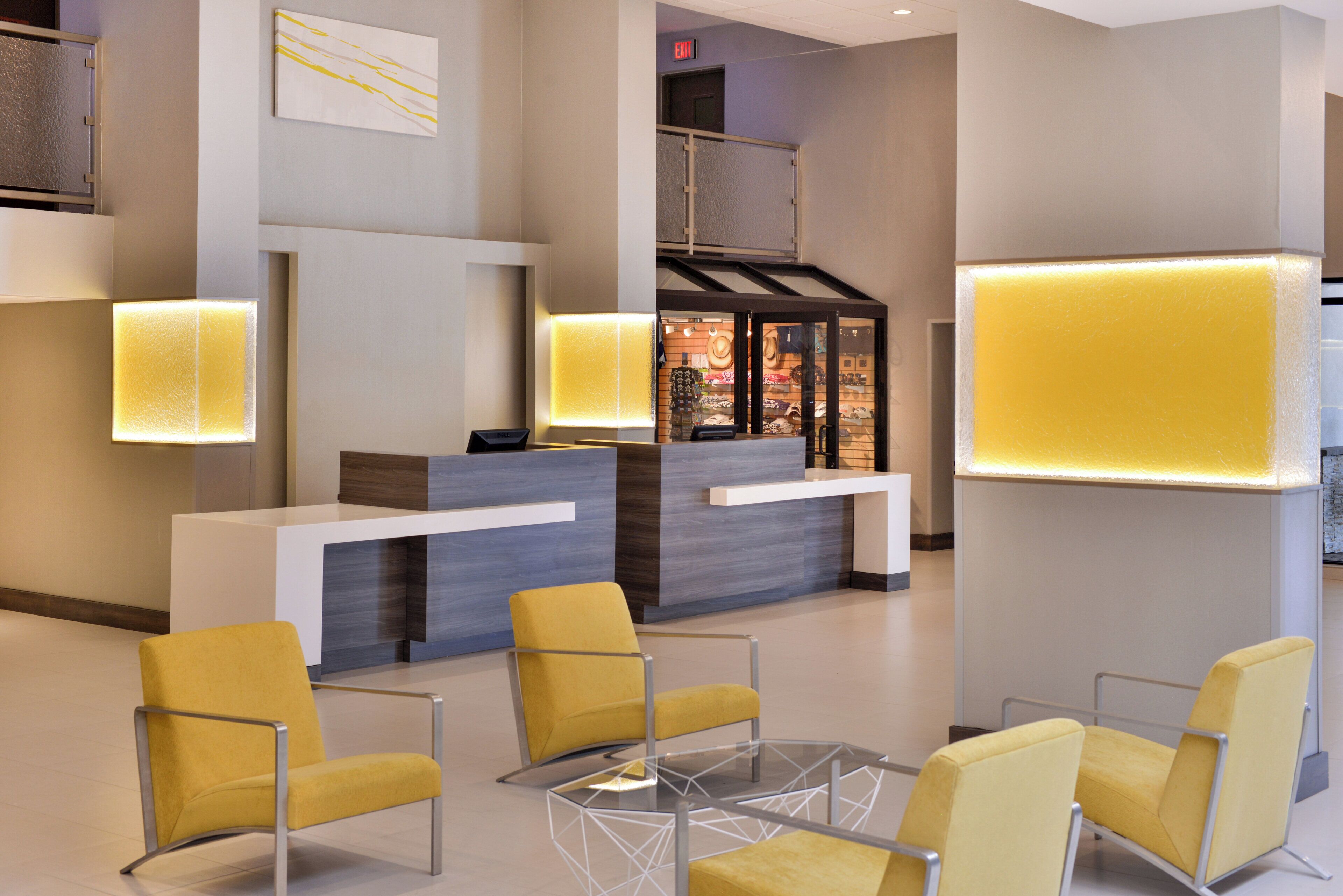 A modern reception area with a desk, chairs, and a glass partition.