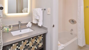 A bathroom with a sink, mirror, and shower. - Holiday Inn Dallas-Richardson by IHG (Richardson)