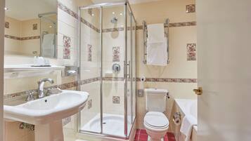 Un baño con ducha de vidrio, lavamanos, inodoro y bañera.