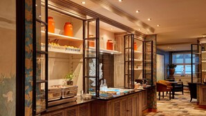 A well-lit kitchen area with a buffet setup, wooden cabinets, and a tiled floor. - Carlton Ambassador Hotel (The Hague)