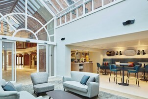 Un interior amplio con techo alto, techo de cristal y zona de cocina moderna.