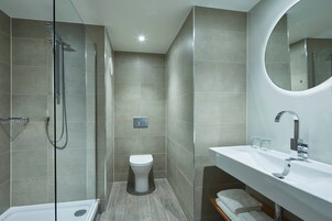 Un baño moderno con ducha, inodoro y lavabo.