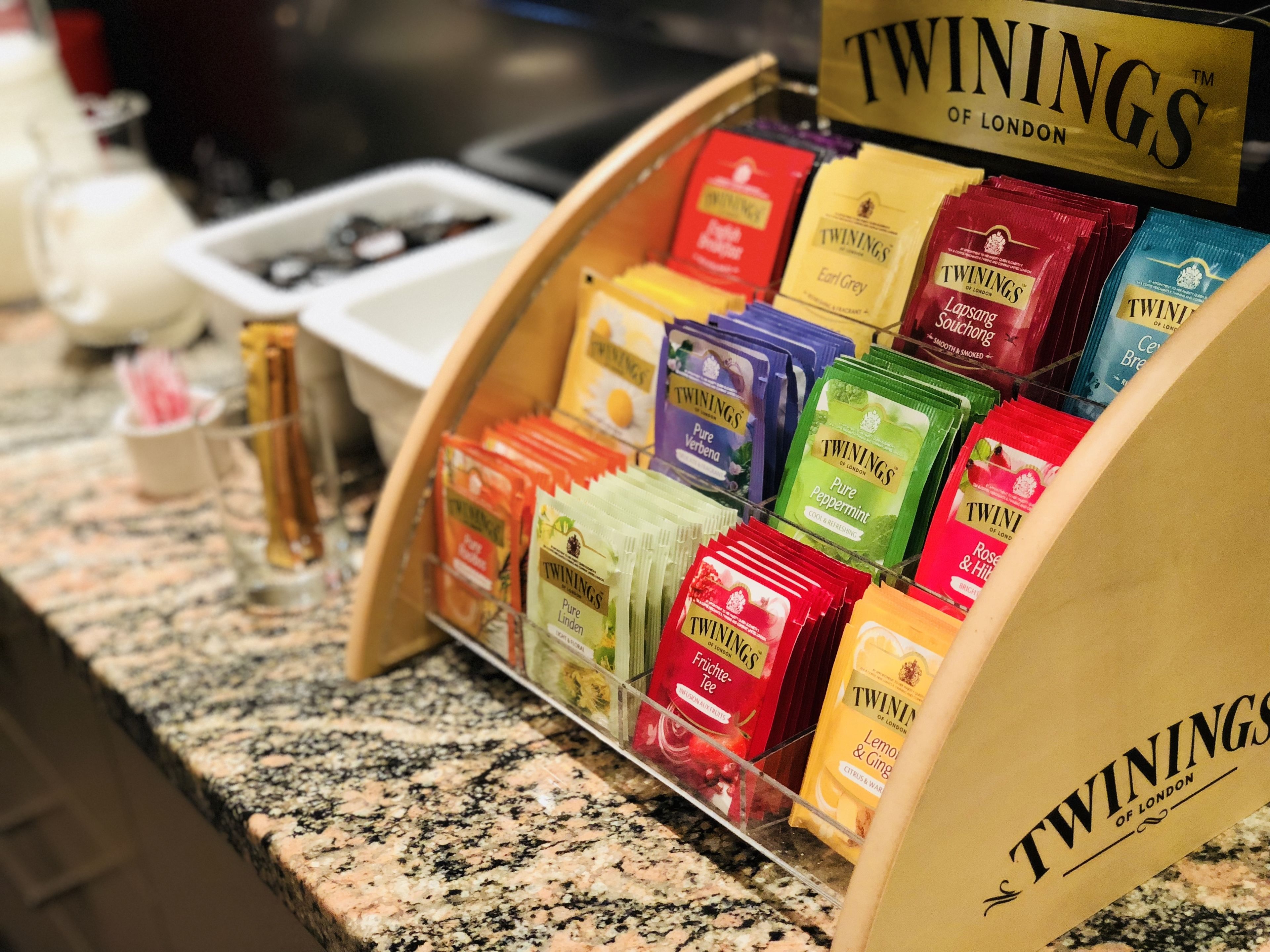 Une sélection de boîtes de thé Twinings de différentes saveurs est exposée sur un comptoir.