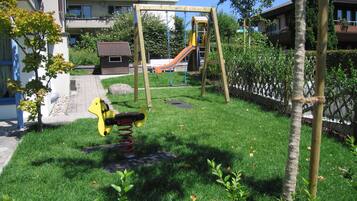 Relax in a serene outdoor space surrounded by lush greenery and mature trees.