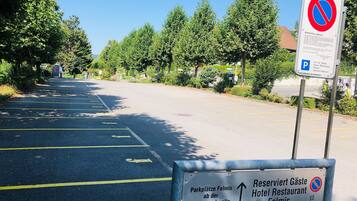 A parking area with directional signs for a hotel and restaurant.