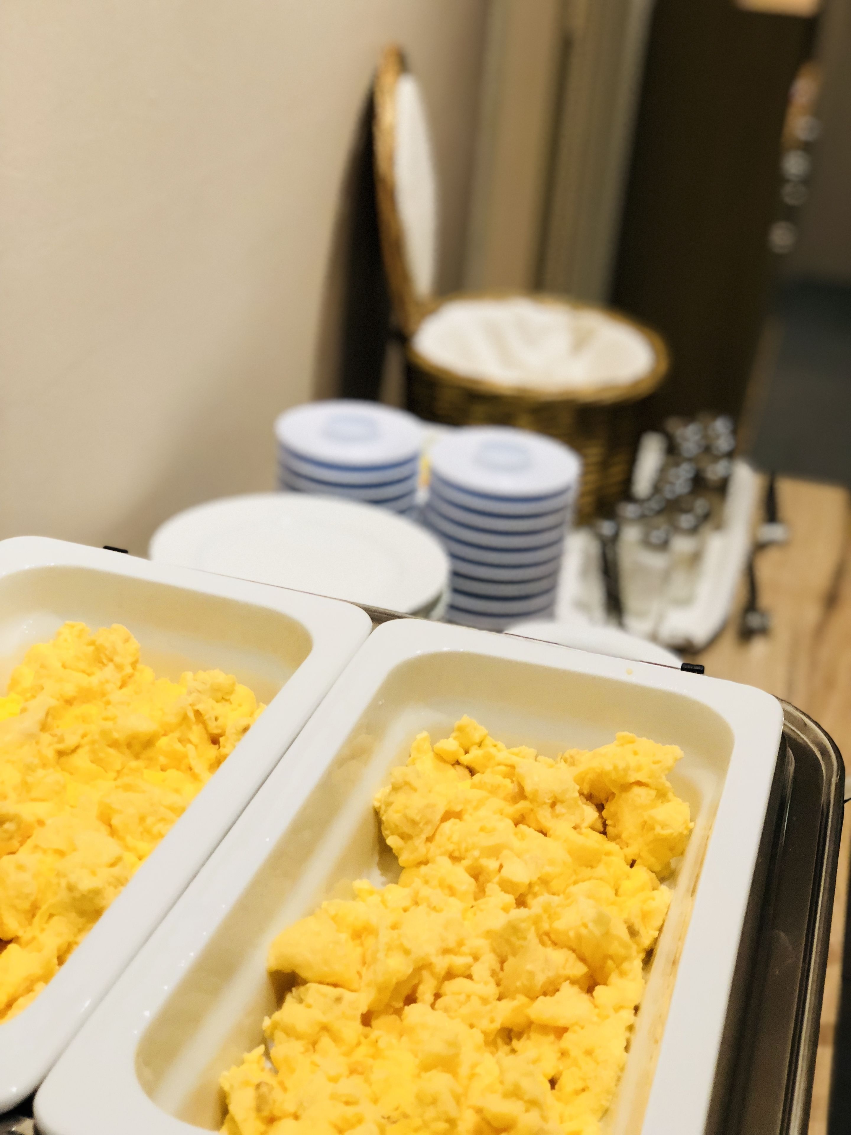 Montaje tipo bufé con huevos revueltos y una variedad de aderezos.