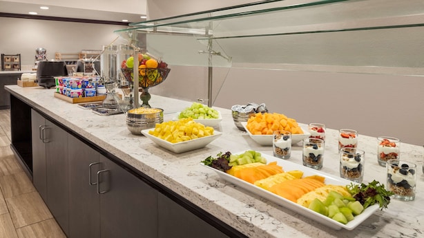Un bufé con diversas frutas, verduras y postres.