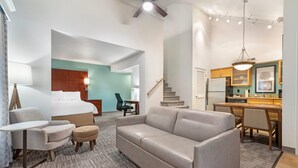 A hotel room with a bed, a sofa, a desk, and a kitchenette. - MainStay Suites St. Louis - Galleria (Richmond Heights)