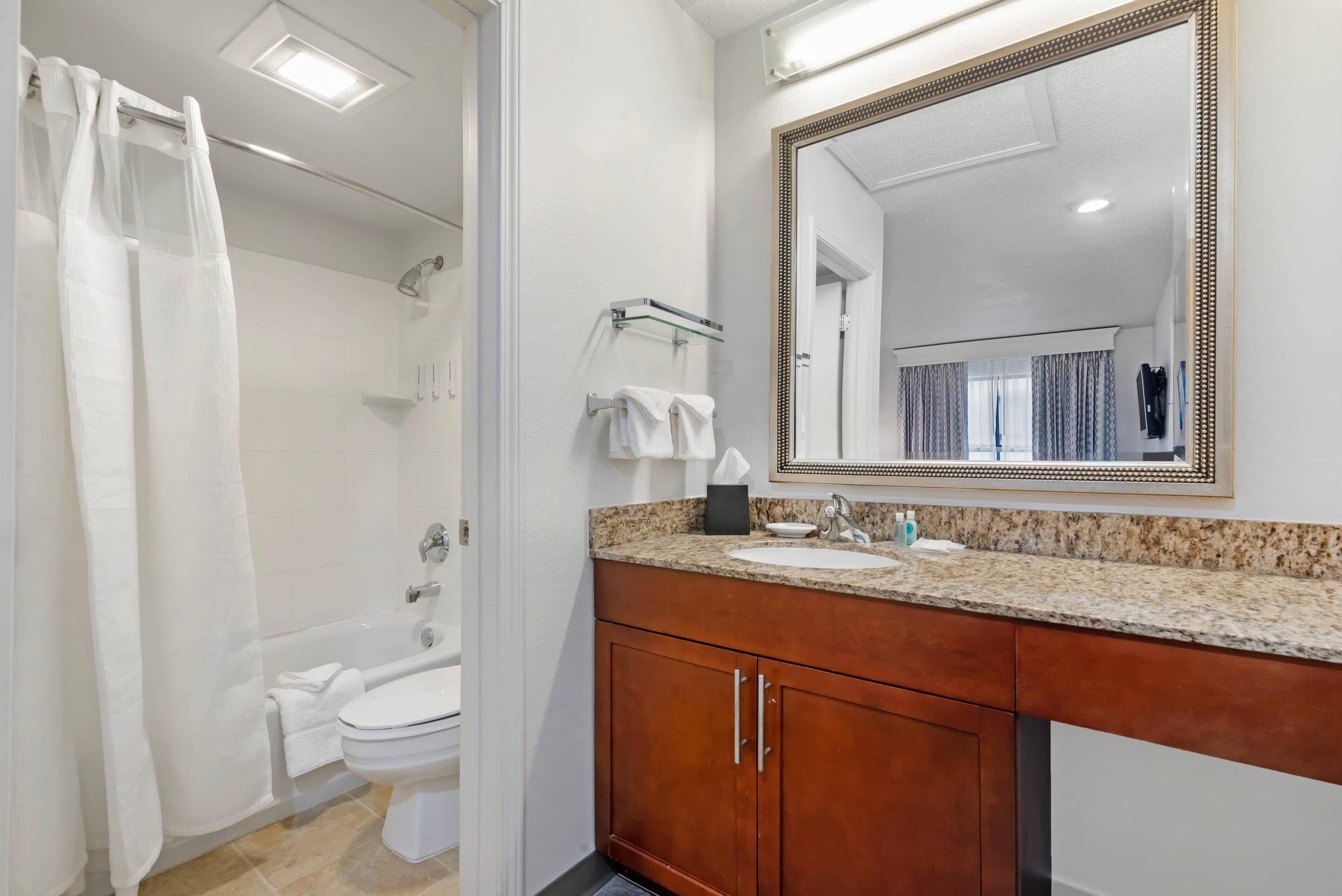 A bathroom with a bathtub, toilet, and sink.