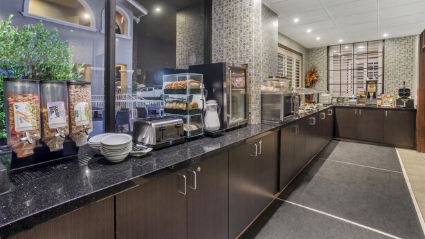 Una cocina moderna con una encimera larga, equipada con dispensador de pan, tostadora y cafetera.
