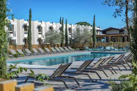 Una piscina al aire libre de temporada, sillones reclinables de piscina