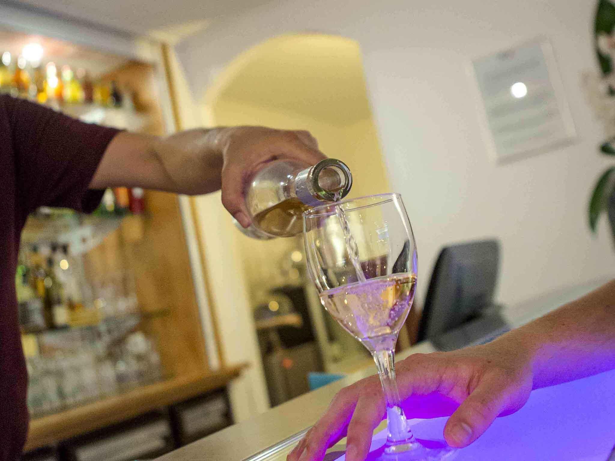 A person pouring a drink into a glass.