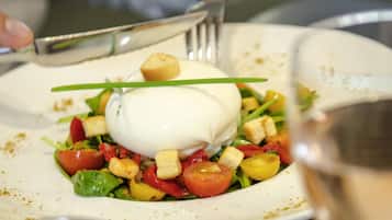 A plate of food with a poached egg, tomatoes, and croutons.