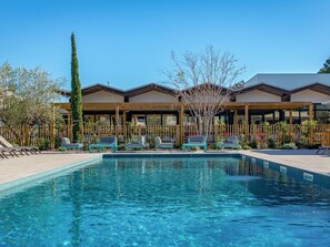 A pool area with lounge chairs and a wooden fence. - Novotel Perpignan Nord Rivesaltes (Rivesaltes)