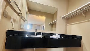 A bathroom with a black sink, a mirror, and a towel rack. - Residential Suites Blue Springs by Hotel O I 70 (Grain Valley)