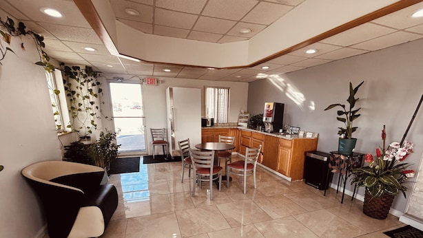 A modern interior with a dining area, a reception desk, and a kitchen. - Residential Suites Blue Springs by Hotel O I 70 (Grain Valley)