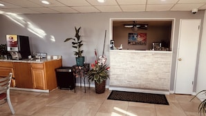 A kitchen with a countertop, a sink, and a dining area with a chair. - Residential Suites Blue Springs by Hotel O I 70 (Grain Valley)