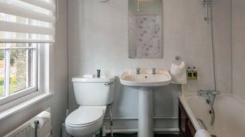 Un baño con inodoro, lavamanos y bañera.