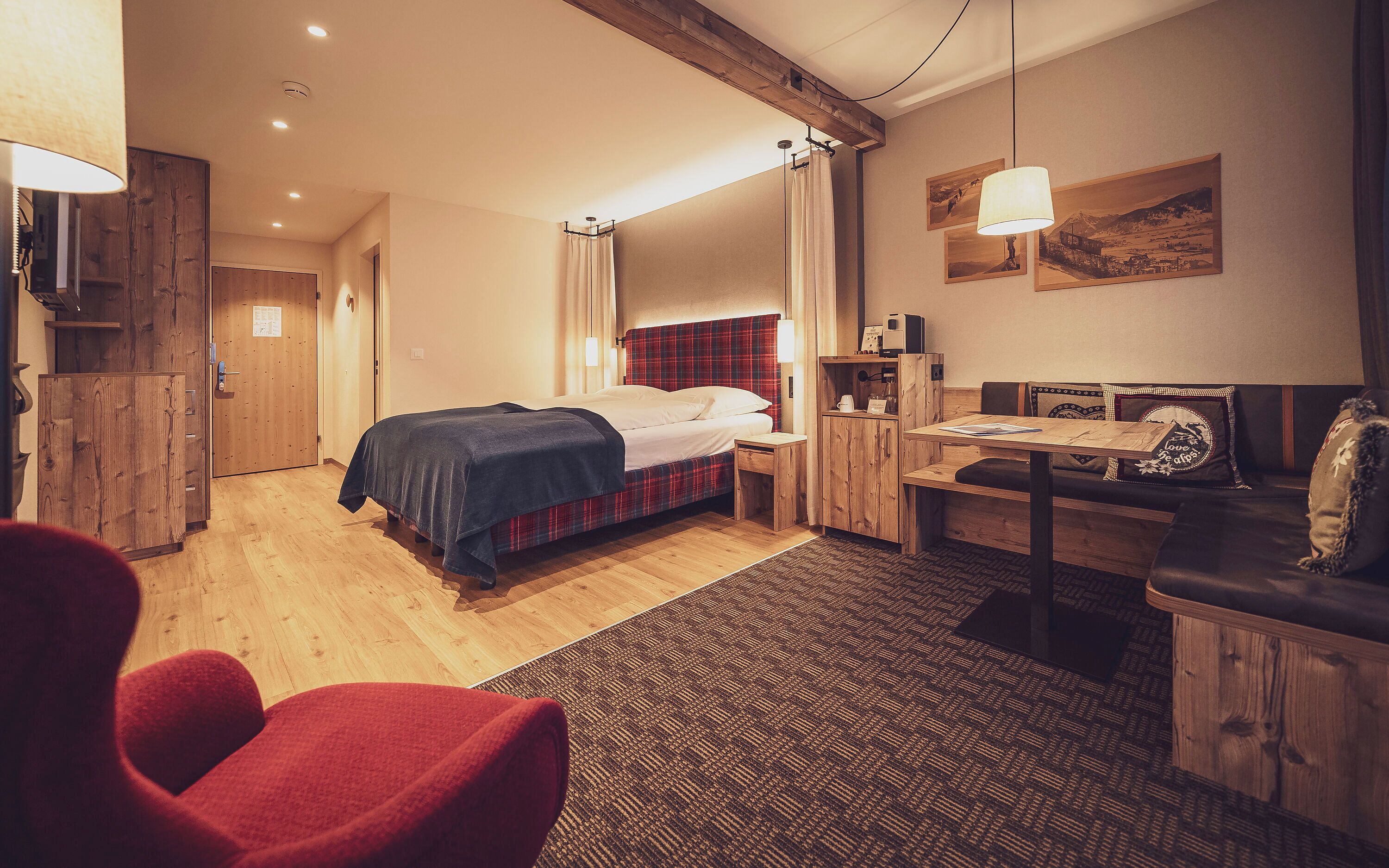 Een hotelkamer met een bed, een bureau, een stoel en een bank.