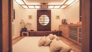 A minimalist room with a bed, a wooden bench, a small table, and a cabinet. - Mountain Plaza Hotel (Davos)
