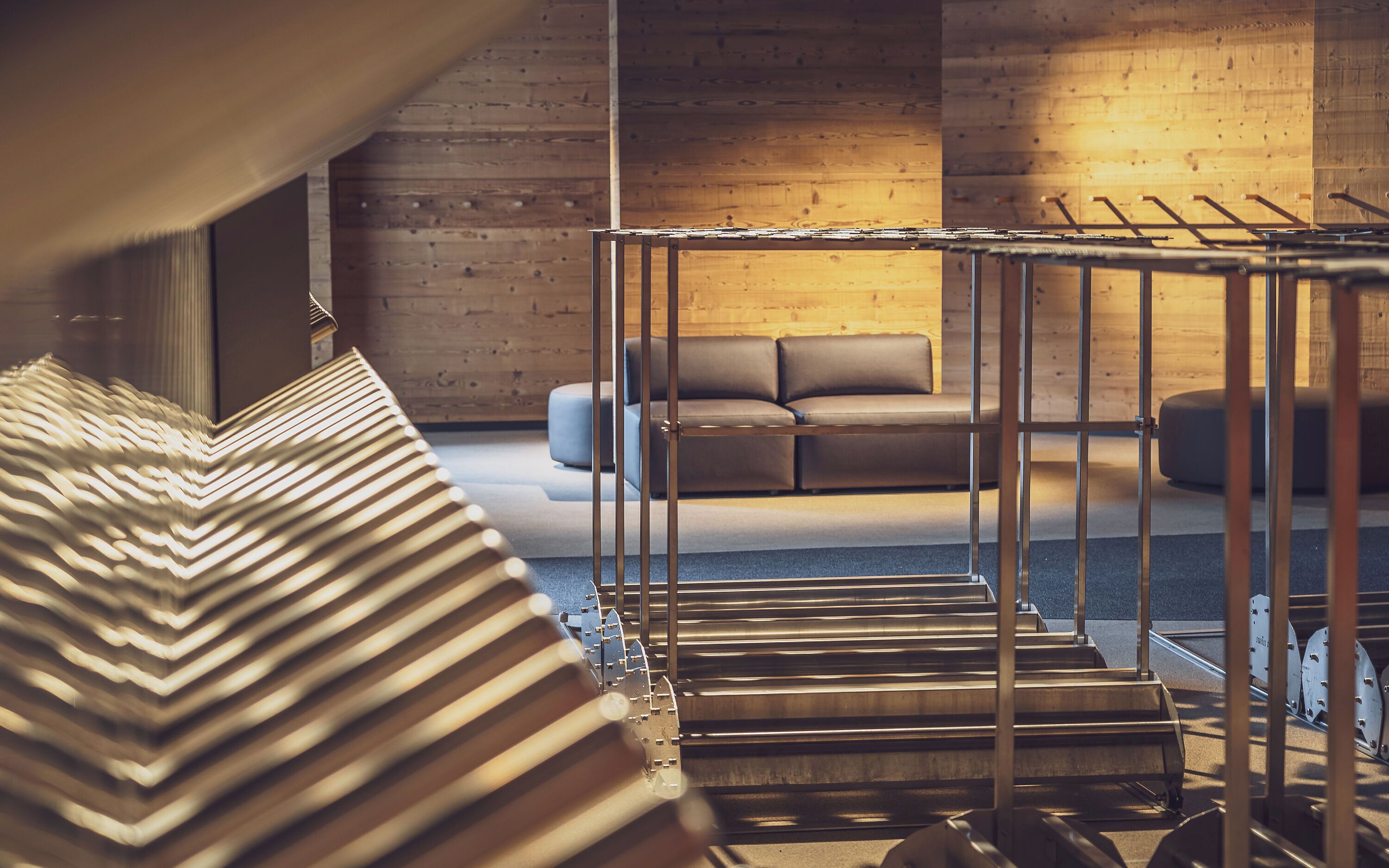 Un interior moderno con una escalera, un sofá y una pared de madera.