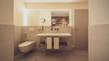 A modern bathroom with a toilet, sink, and towel rack.