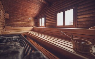 Un sauna con bancos de madera y un ventanal grande.