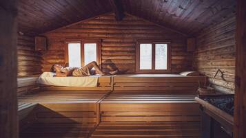 Une cabane avec un lit en mezzanine, une fenêtre et un intérieur en bois.