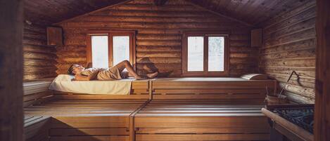 Une cabane avec un lit en mezzanine, une fenêtre et un intérieur en bois.