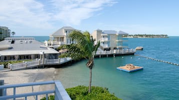 A coastal hotel with a beach view, a dock, and a small boat.