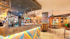 A bar area with a wooden counter, multiple taps, and a sign that reads "SMILE".