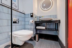 Un baño moderno con inodoro, lavabo y espejo.