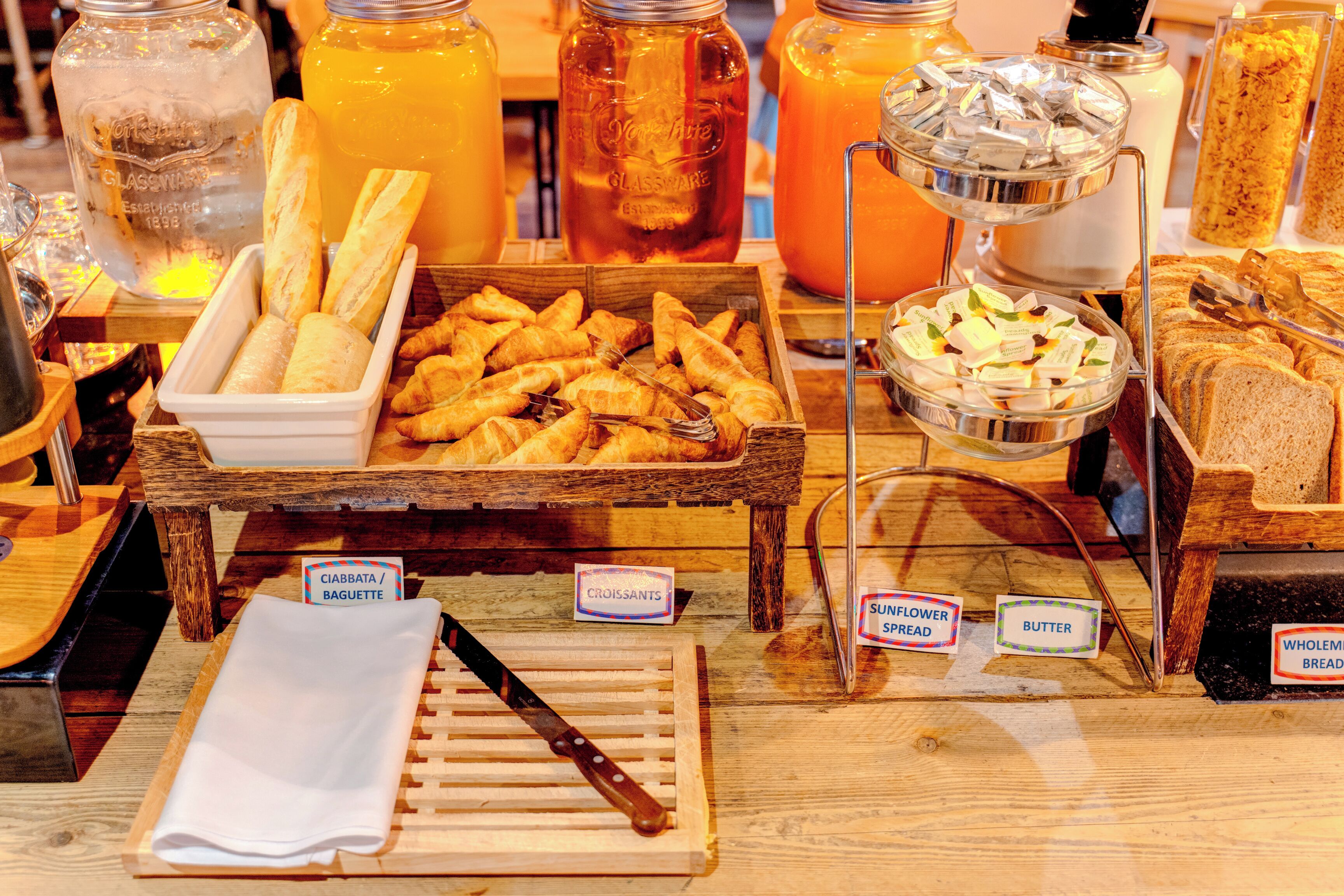 A breakfast buffet with various food items and labels.