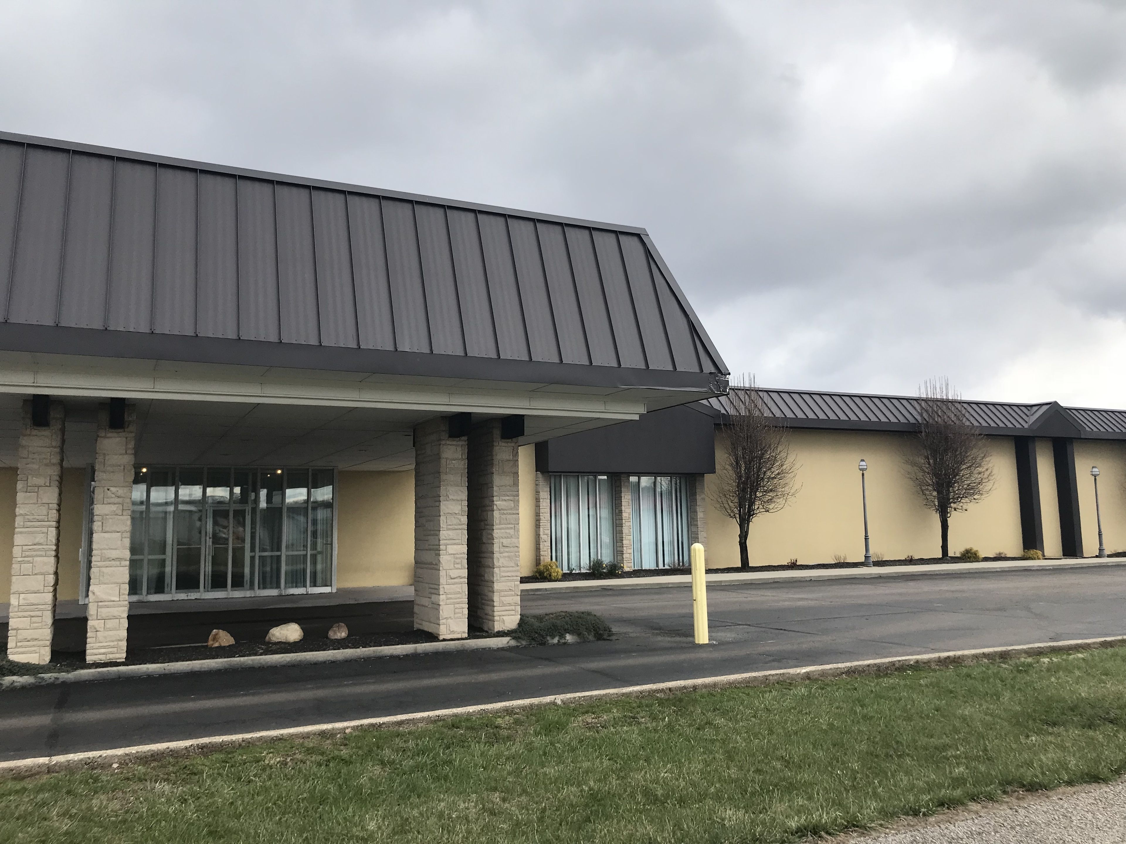 Un bâtiment doté d’un toit plat et de piliers en pierre.