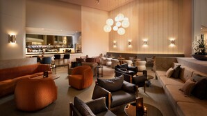 Un espace de détente moderne avec des canapés, des fauteuils et un bar.