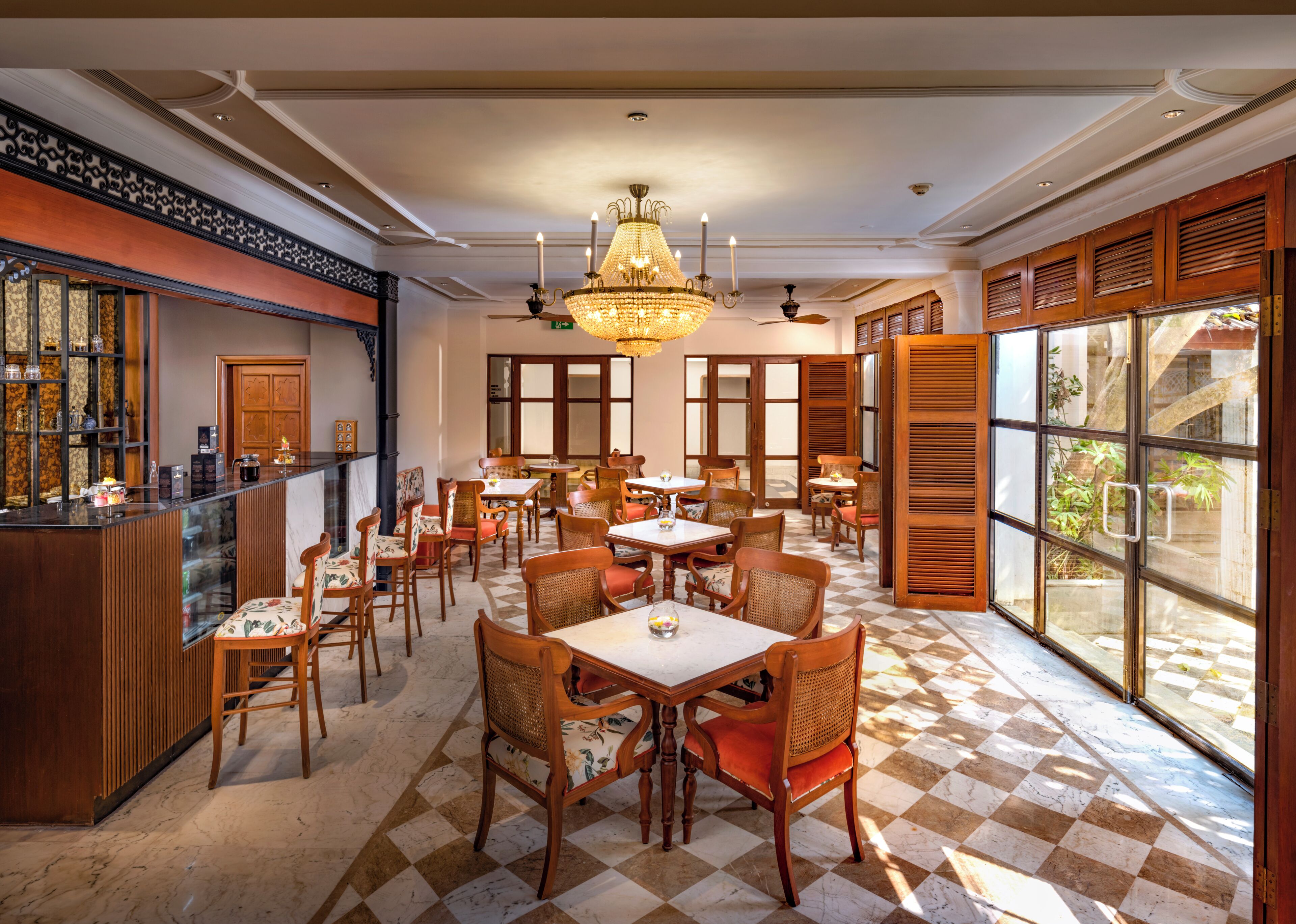 A restaurant with checkered flooring, wooden furniture, and large windows.