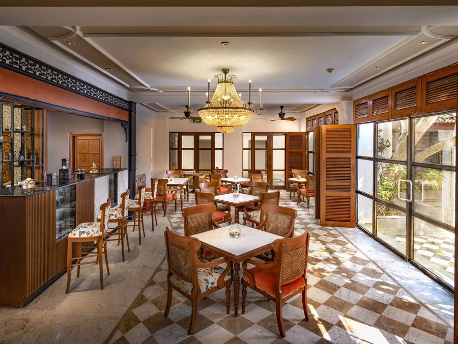 Un comedor espacioso con muebles de madera, una araña y ventanas amplias.
