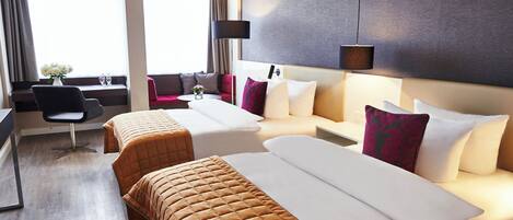 Una habitación de hotel con dos camas, un escritorio, una silla y un ventanal grande con cortinas.