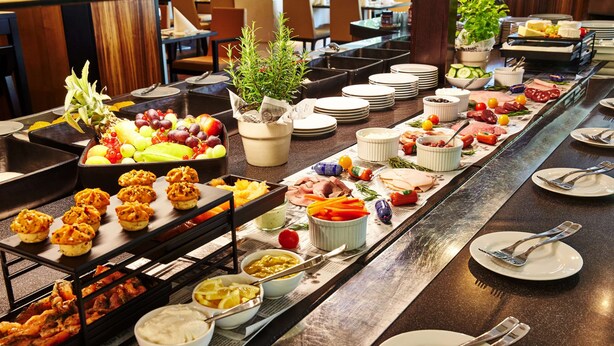A buffet with various food items and utensils laid out on a table. - Steigenberger Hotel Köln (Cologne)