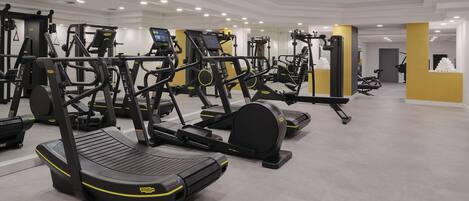 Ein modernes Fitnessstudio mit verschiedenen Cardio-Geräten, darunter Laufbänder und Crosstrainer.
