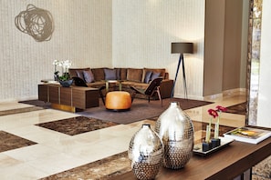 A modern living room with a sectional sofa, a coffee table, and decorative vases.